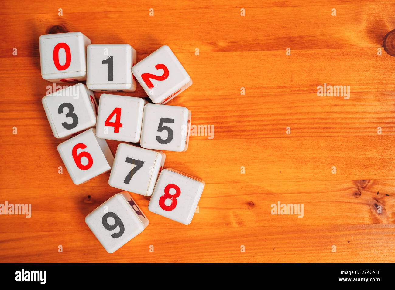 Zahlen lernen und mathematische Berechnung, Draufsicht auf Plastikwürfel mit Zahlen auf Holztisch, direkt darüber Stockfoto