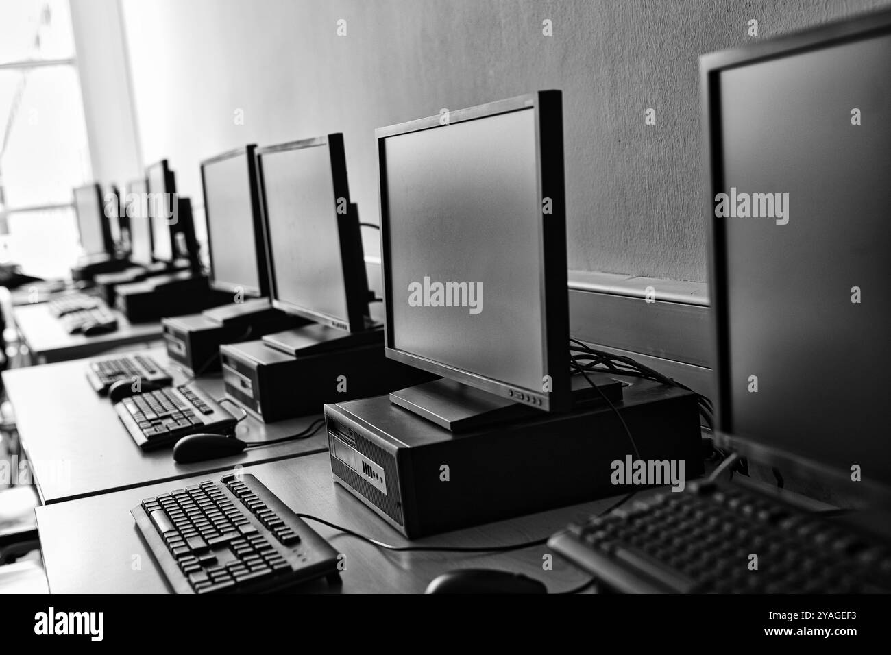 Eine Reihe von Desktop-Computern in einem hellen Labor, die darauf warten, dass Schüler lernen und recherchieren. Geräumiges, modernes Interieur für Online-Zugang zu Wissen. Linien Stockfoto