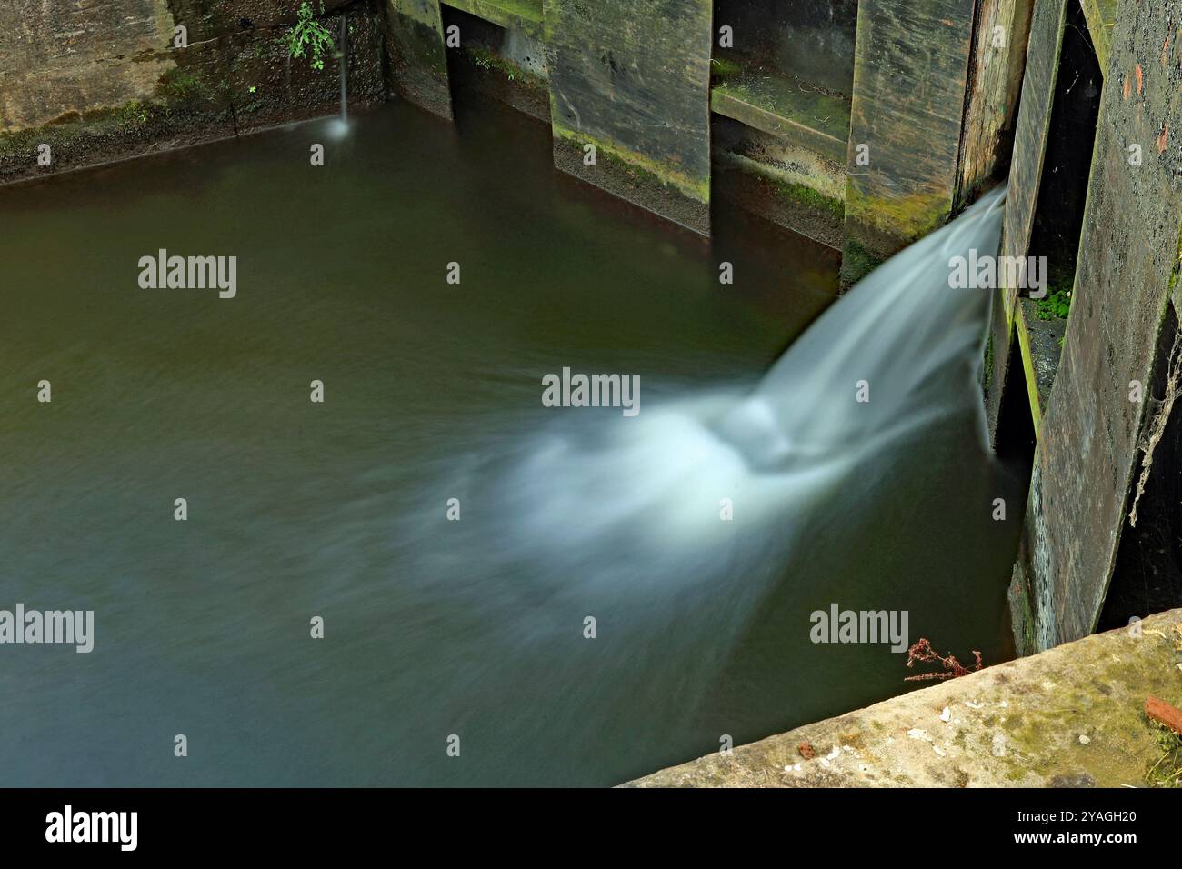 Die unteren Tore, auf Schleuse vier des Rufford-Arms des L- und L-Kanals, haben ein leichtes Leck an ihnen, aufgenommen mit einer langsamen Verschlusszeit, also milchiges Wasser. Stockfoto