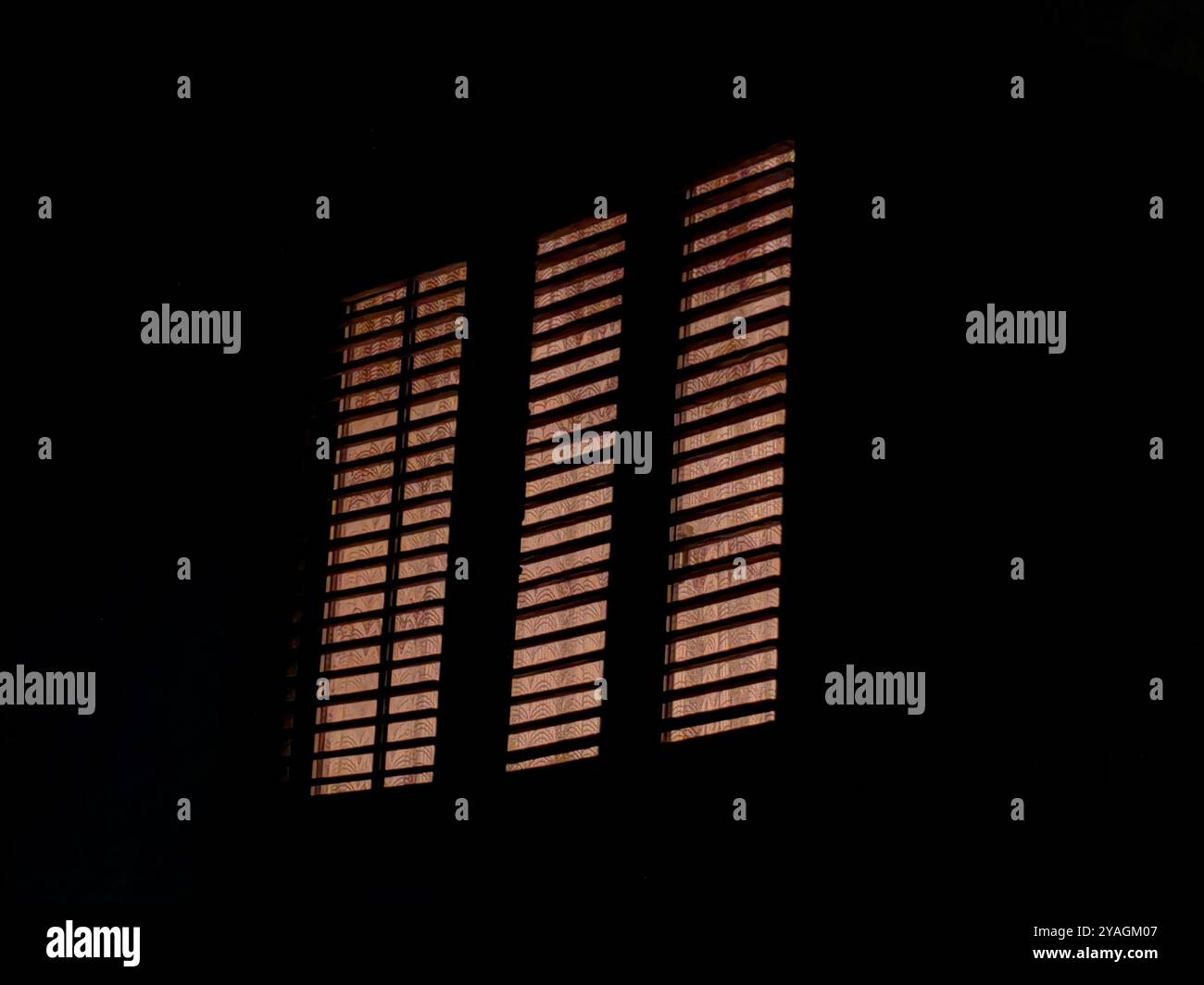 Dreifacher Fensterrahmen bei Nacht: Beleuchtetes Zuhause im Dunkeln. Abstrakte Musik-Lautstärkeregler. Stockfoto