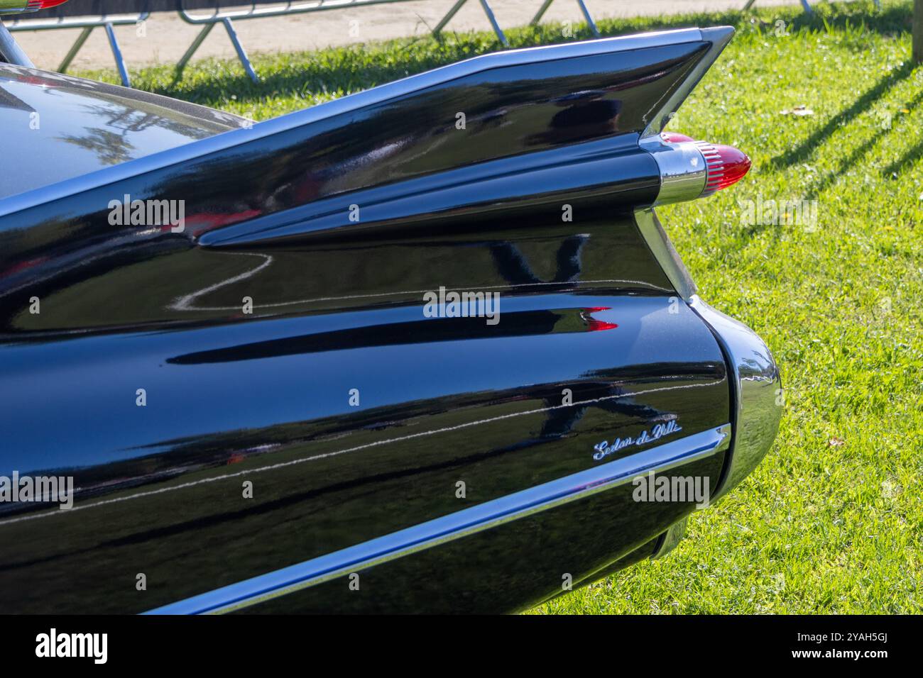 Die glänzende schwarze Farbe eines Vintage cadillac Coupé deville spiegelt das umgebende Gras und den Himmel wider Stockfoto