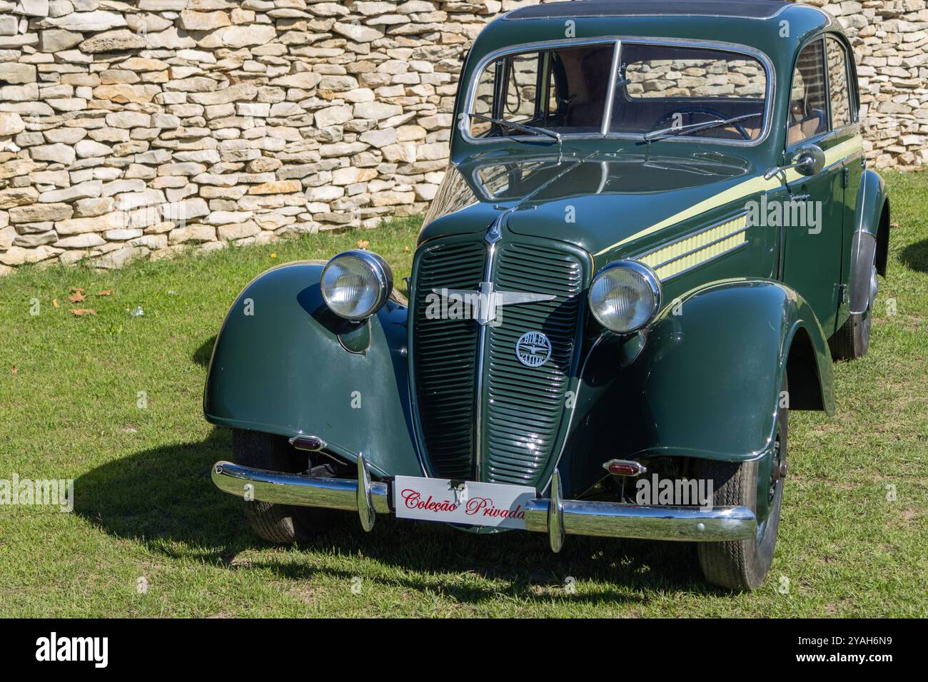 Die unberührte tatra 57, ein klassischer tschechoslowakischer Wagen aus den 1930er Jahren, steht auf Gras nahe einer Steinmauer Stockfoto