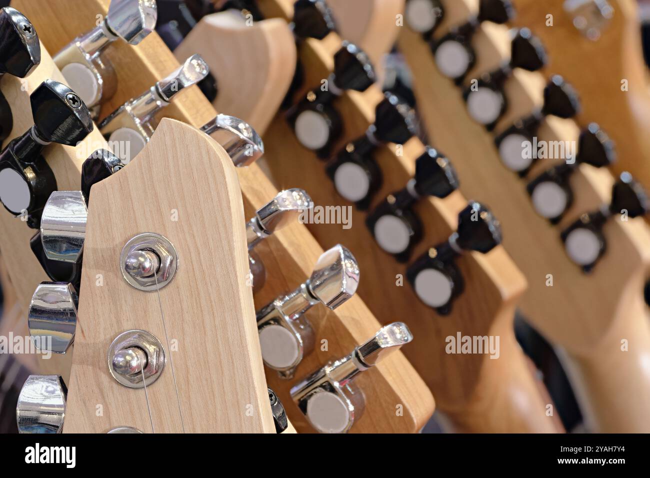 Gruppe von Gitarren, traditionelle Saiteninstrumente. Nahaufnahme von Kopfstöcken, abstrakter Hintergrund aus der Musikindustrie. Stockfoto