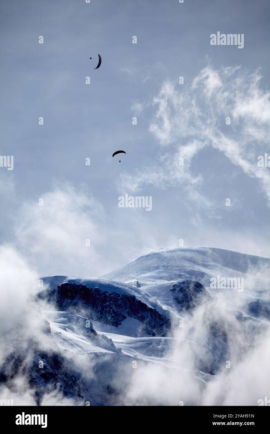 Gleitschirmflieger am Himmel über Chamonix in den Alpen, Frankreich. Extremsport. Schneebedeckte Berggipfel. Stockfoto