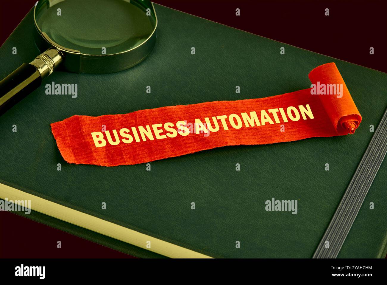 Das Konzept des Info-Geschäfts. Der Text der GESCHÄFTSAUTOMATISIERUNG ist auf einem Stück aufgeklappten roten Notiz, Papier auf einem grünen Buch geschrieben. Gesättigte Farben. Stockfoto