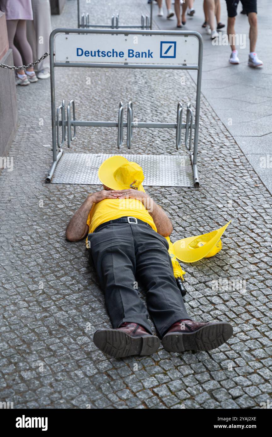 29.06.2024, Deutschland, , Berlin - Europa - Ein Teilnehmer an einer Demonstration gegen den Iran macht ein Nickerchen neben einem Fahrradträger einer Niederlassung der Deutschen Bank Stockfoto