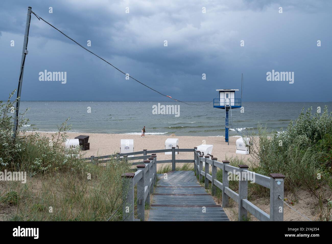 28.07.2024, Deutschland, Mecklenburg-Vorpommern, Heringsdorf - Europa - über den leeren Sandstrand der Ostsee ziehen dunkle Wolken Stockfoto