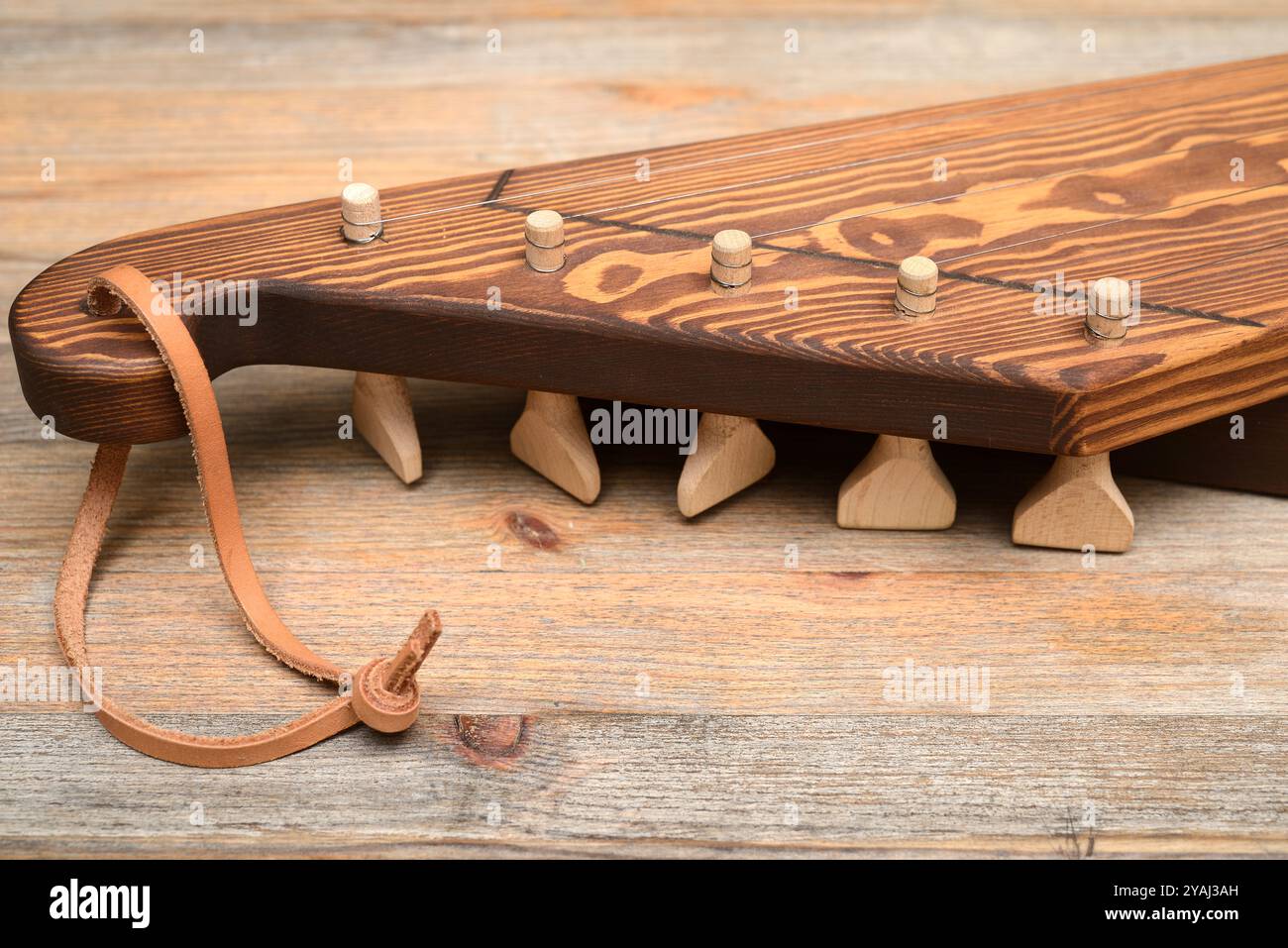 Dieses Bild zeigt eine Nahaufnahme eines hölzernen Musikinstruments mit einem rustikalen, handgefertigten Design. Die hölzerne Textur der bo des Instruments Stockfoto