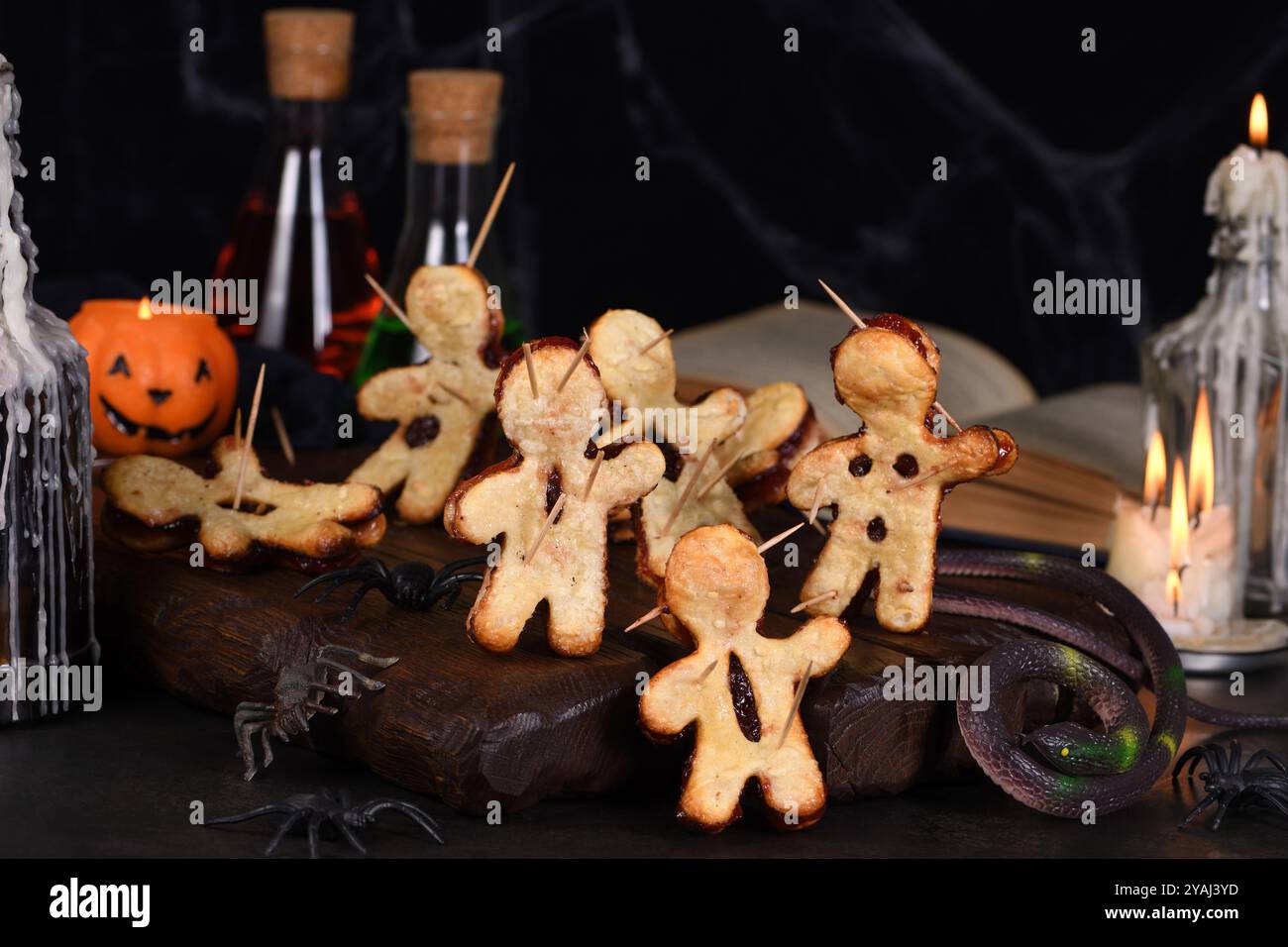 Voodoo-Kekse aus Blätterteig mit Marmelade und mit Holzspießen durchstochen. Idee für die Halloween-Party Stockfoto