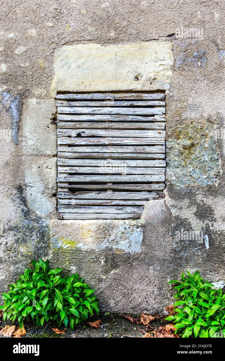Blockiertes kaputtes Fenster in der Steinmauer des alten Gebäudes - Le Petit-Pressigny, Indre-et-Loire (37), Frankreich. Stockfoto
