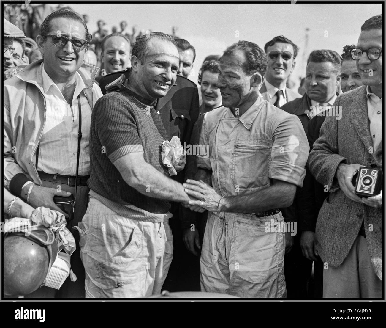 Stirling Moss gratuliert Juan Fangio zu seinem Sieg beim Großen Preis von Nederland in Zandvoort. Der Sieger J. M. Fangio (links) wird von seinem Teamkollegen Stirling Moss gratuliert, der beide für Mercedes am 19. Juni 1955 North Holland fuhr, Zandvoort Fangio J.M., Moss, Stirling Stockfoto