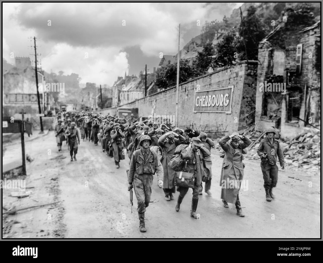 Deutsche Gefangene marschieren aus der Stadt Cherbourg, Normandie, Frankreich, im Juni 1944, UM DEN Kapitän der NORMANDIE W.H. Hooper, der den 314. Inf kommandiert. Der 79. US-Ausweis und einige seiner Männer flankierten eine Kolonne deutscher Gefangener, Offiziere an der Spitze. Sie gehen die Avenue de Paris in Cherbourg hinauf, passieren vor der Inschrift „Cherbourg“ die Säule nach Süden und erreichen die Kriegsgefangenenlager auf dem Plateau Montagne du Roule, Normandie Frankreich im Juni 1944 Stockfoto