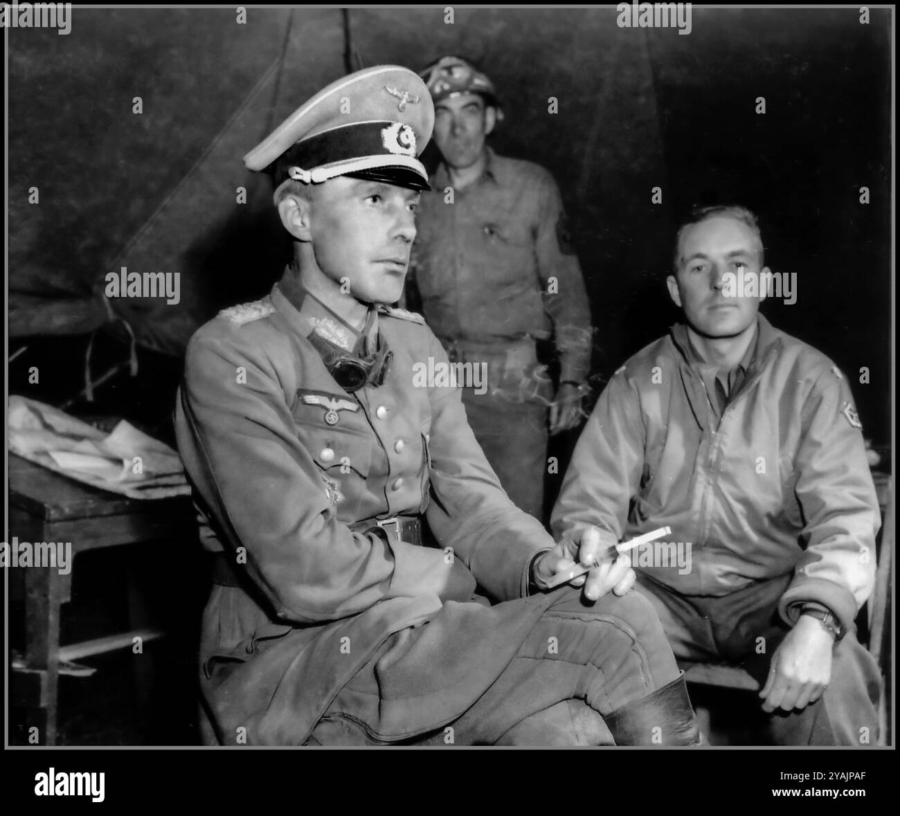 Kriegsgefangenenoffizier Wehrmacht-Generalleutnant Otto Elfeldt, 1944, raucht ruhig eine Zigarette vor seinem Verhör in Saint Lambert sur Dive. Generalleutnant Elfeldt, Kommandeur der LXXXIV AK, wurde am 20. August 1944 in der Nähe von Moissy vom 10. Pferdejägerregiment Pulk Strzelcow Konnych, Aufklärungsregiment 1. Polnische Panzerdivision gefangen genommen. Er erscheint hier in Begleitung eines amerikanischen Soldaten vom 701. Panzerzerstörer BN. Am 20,1944. August wurde er von den alliierten Truppen im September 1944 während des Rückzugs deutscher Truppen in Nordfrankreich gefangen genommen. Stockfoto