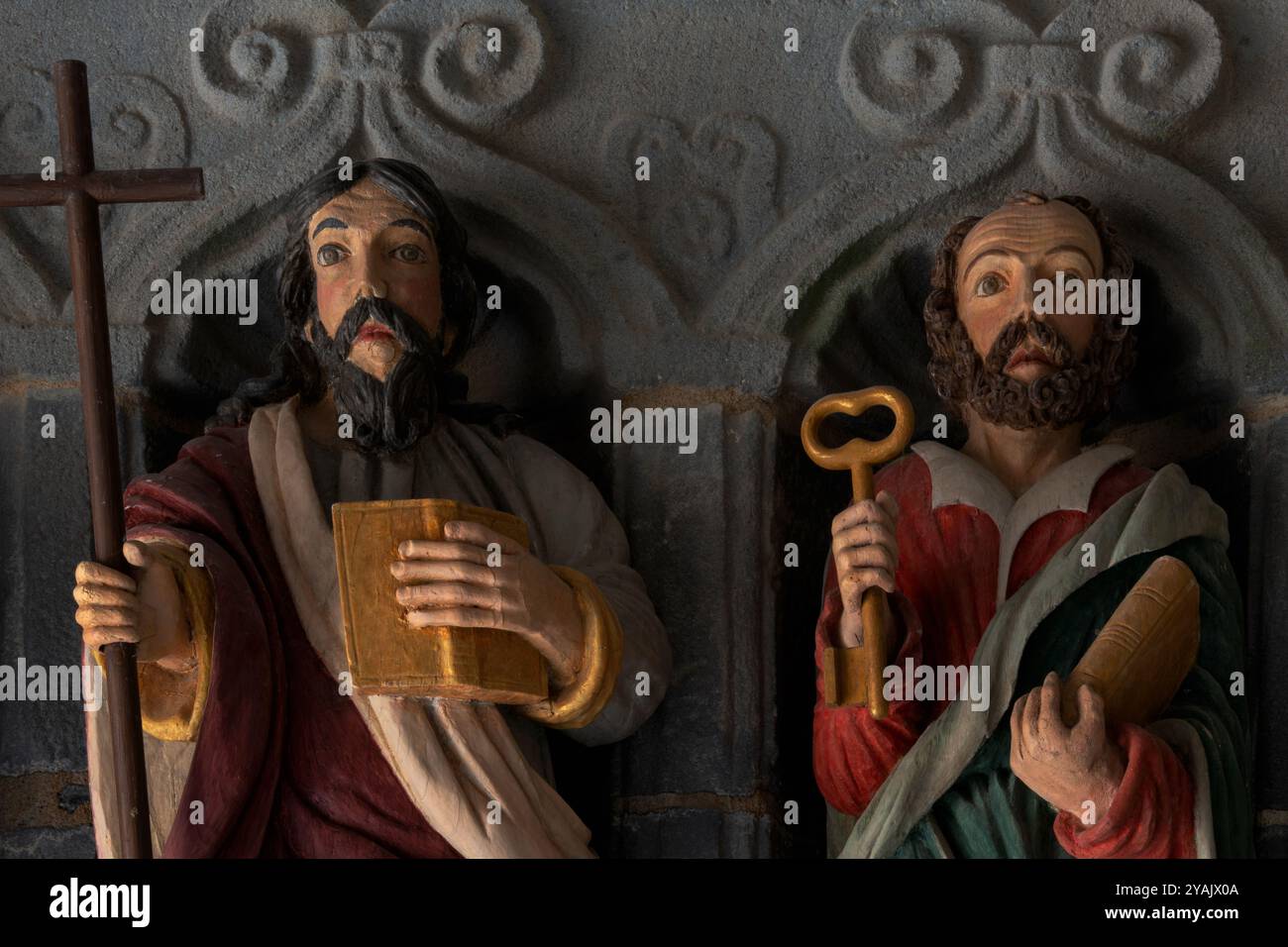Der Heilige Philipp und der Heilige Peter. Köpfe und Oberkörper von zwei von 12 polychromen Apostelstatuen, die 1721 in Holz gemeißelt wurden und den Eingang einer bretonischen Kirche, L’Eglise Saint Sauveur, in Le Faou, Finistère, Bretagne, Frankreich, flankieren. Stockfoto