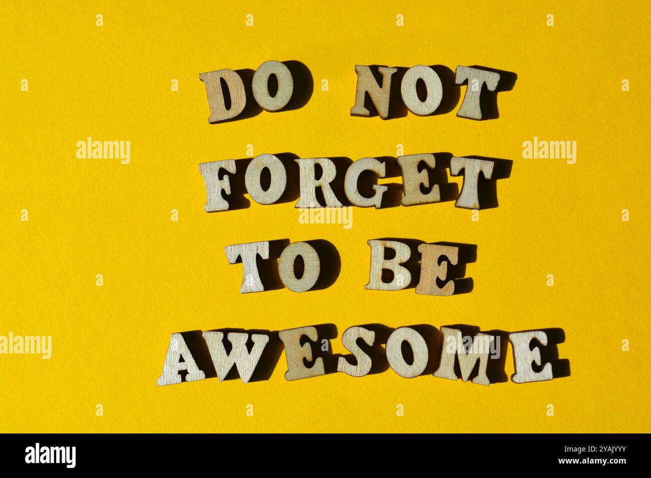 Vergessen Sie nicht, fantastisch zu sein, Wörter in hölzernen Buchstaben isoliert auf gelbem Hintergrund Stockfoto