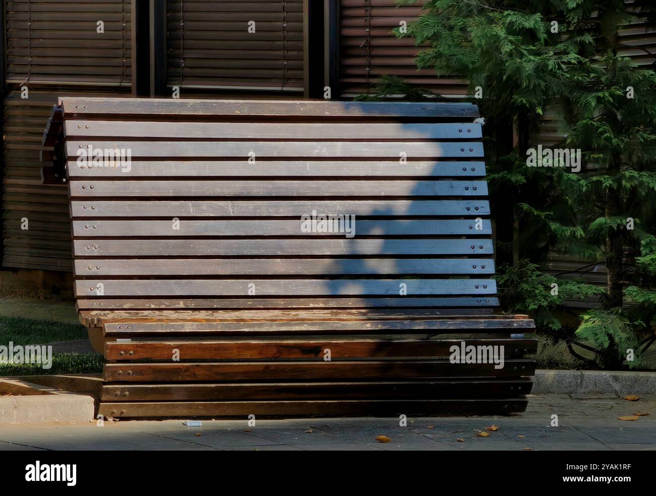 Urban Park Bench in Shadows: Eine Straßenfotografie-Perspektive Stockfoto