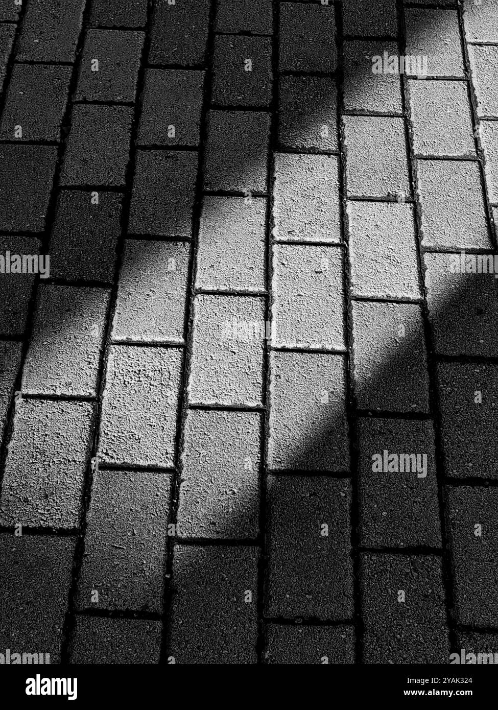 Sunlit Pavement: Ein Tanz aus Licht und Schatten Stockfoto