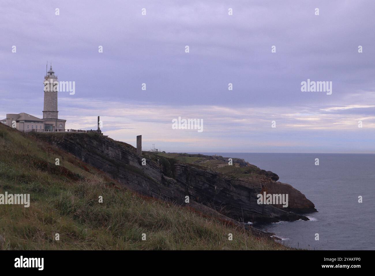 Der Leuchtturm von Santander auf felsigen Klippen mit Blick auf das ruhige Meer unter bewölktem Himmel in Kantabrien, Spanien. Stockfoto Der Leuchtturm von Santander auf felsigen Klippen mit Blick auf das ruhige Meer unter bewölktem Himmel in Kantabrien, Spanien. Stockfoto