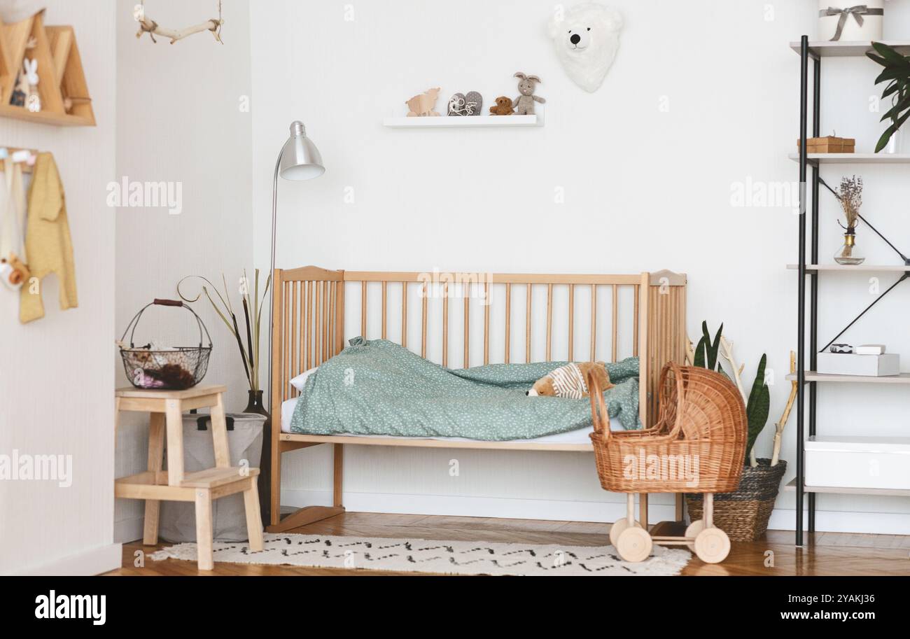 Baby Schlafzimmer Innenraum mit gemütlichen Bett aus Holz und Korbgeflecht Kinderwagen Stockfoto