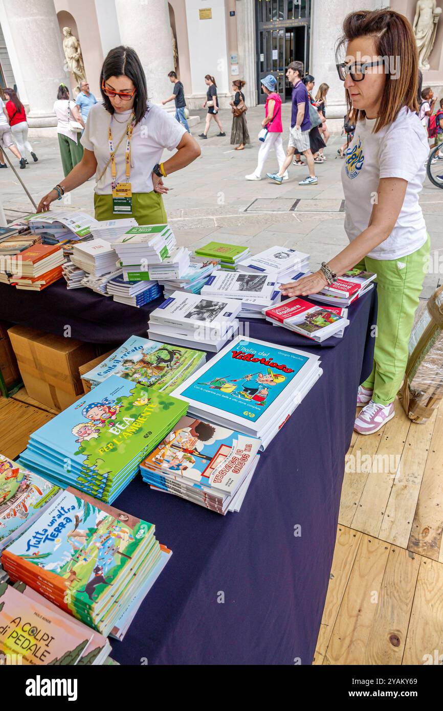 Triest Italien, Piazza della Borsa, Bürgersteig Straßenbuchverkäufer Kinder, Frauen Arbeiter, Italienisch Europa Europäische EU, Besucher reisen Touris Stockfoto