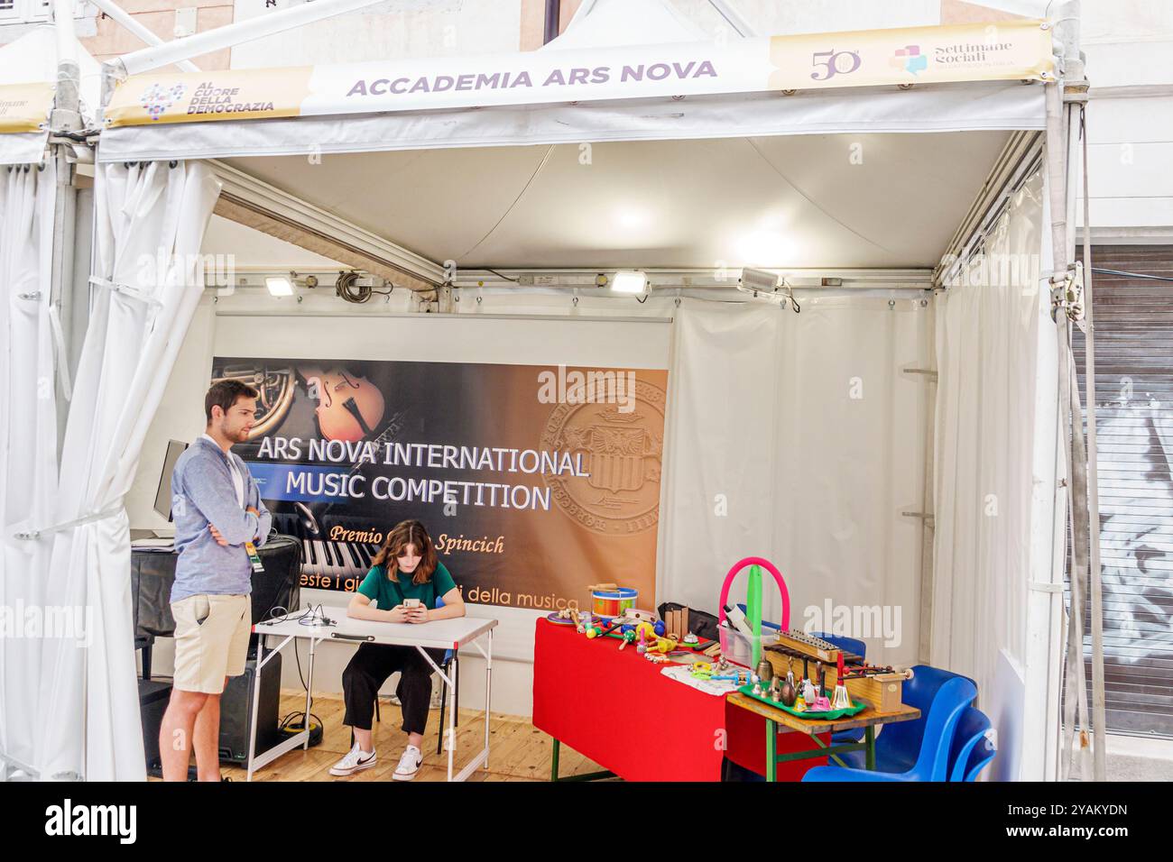 Triest Italien, Triest Estate Summer Fair, Accademia Ars Nova, Musikakademie, die Wettbewerbsbanner fördert, Stand, freiwillige Studenten, männliche weibliche Männer Stockfoto