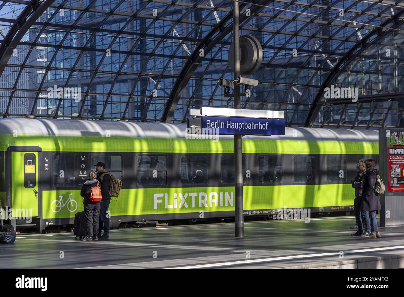 Hauptbahnhof, säulenlose Glasdachkonstruktion über den Bahnsteigen, Bahnhofsschild und Zug der Eisenbahngesellschaft Flixtrain. Berlin, Deutschland, Eur Stockfoto