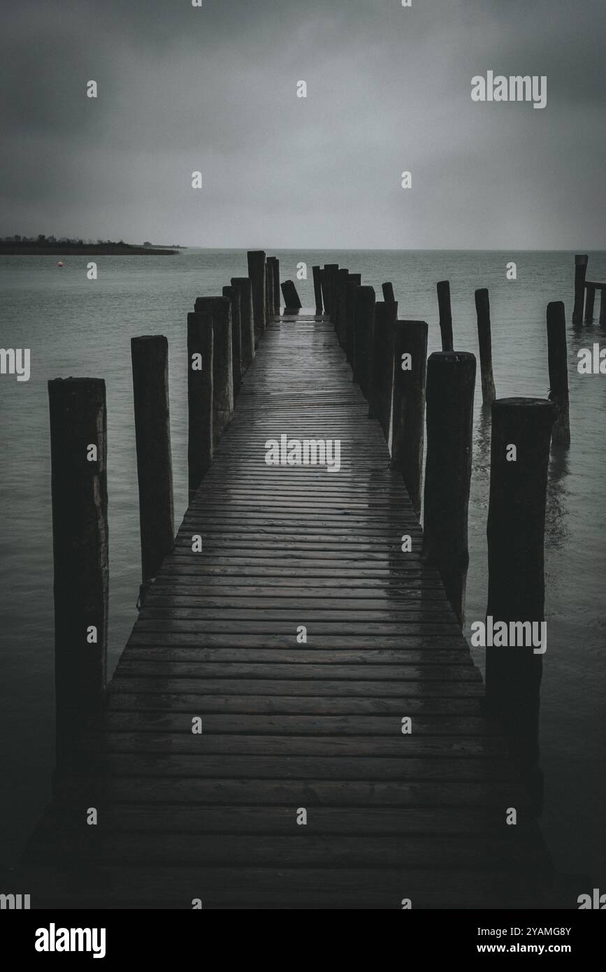Steg ragt in einen düsteren, bewölkten See, Podersdorf, Burgenland, Österreich, Europa Stockfoto