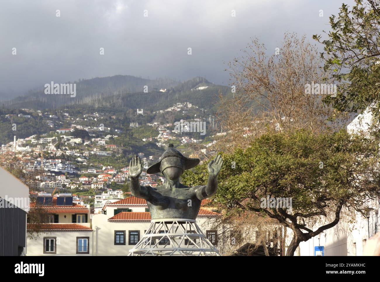 Interessante moderne Bronzestatue einer Frau mit verbundenen Augen vor der bergigen und bewölkten Landschaft Madeiras Stockfoto