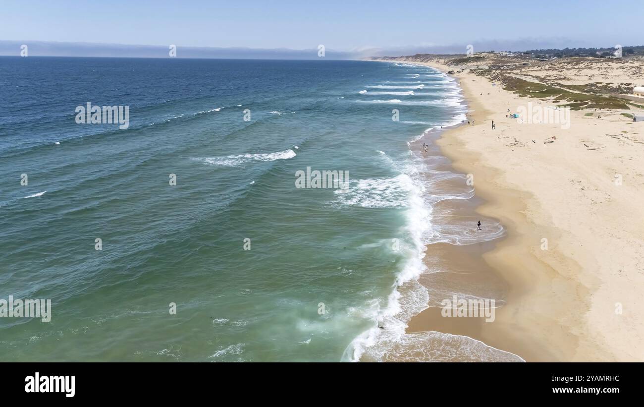 Schwimmer gleiten an einem perfekten Sommertag durch die kristallblauen Wellen vor der kalifornischen Küste unter der goldenen Sonne und malen ein ruhiges aquatisches Tableau Stockfoto