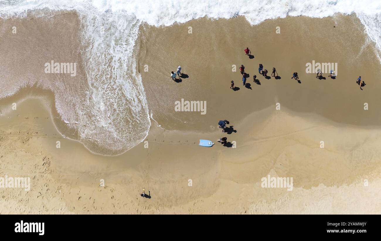 Schwimmer gleiten an einem perfekten Sommertag durch die kristallblauen Wellen vor der kalifornischen Küste unter der goldenen Sonne und malen ein ruhiges aquatisches Tableau Stockfoto