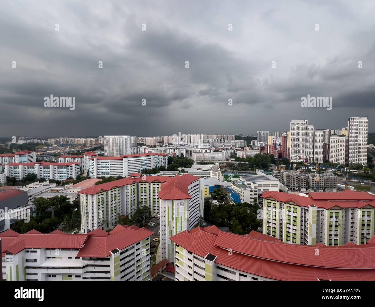Aus der Vogelperspektive sehen graue Wolken über dem Himmel. Bedingungen zwischen Monsun. Es wird mit kurzzeitigen Gewitterschauern gerechnet. Singapur. - Smartphone-aufgenommenes Stockfoto