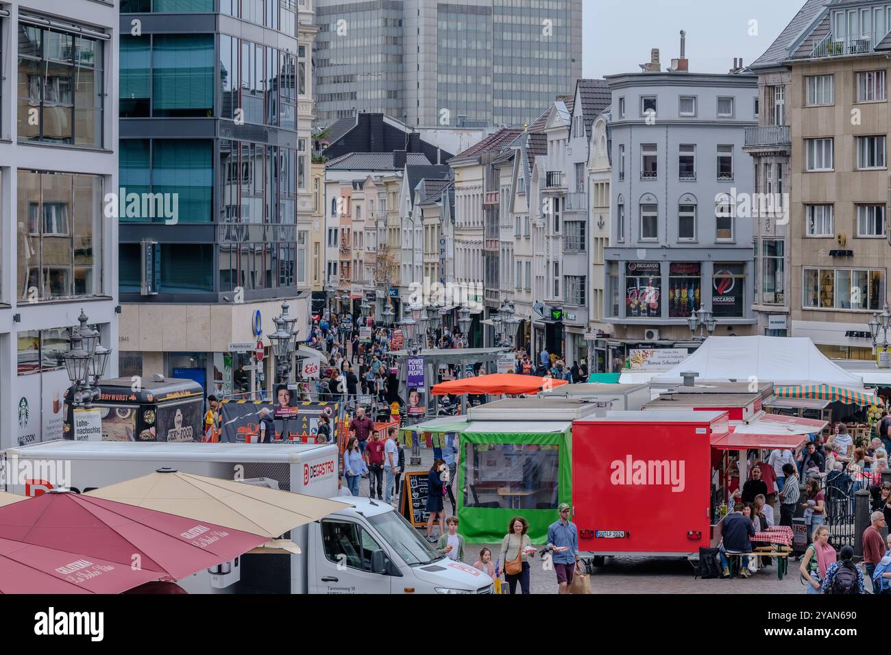 Bonn, Deutschland - 21. Mai 2024 : Blick auf den Bonner Marktplatz mit verschiedenen Food Trucks , Cafés, Geschäften, Restaurants und Menschen Stockfoto