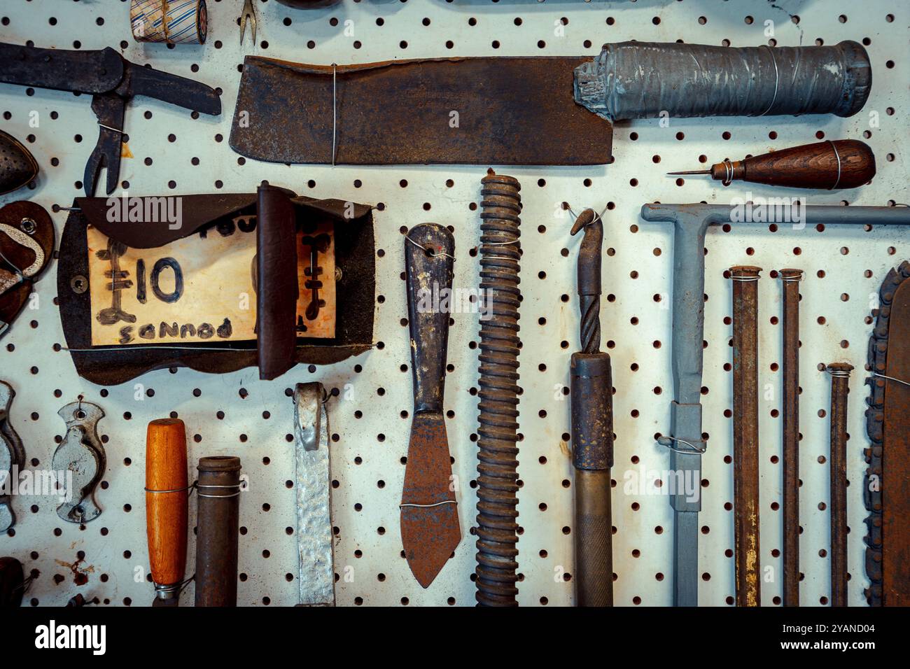 Eine Sammlung alter Handwerkzeuge, die an der Wand angeordnet sind Stockfoto