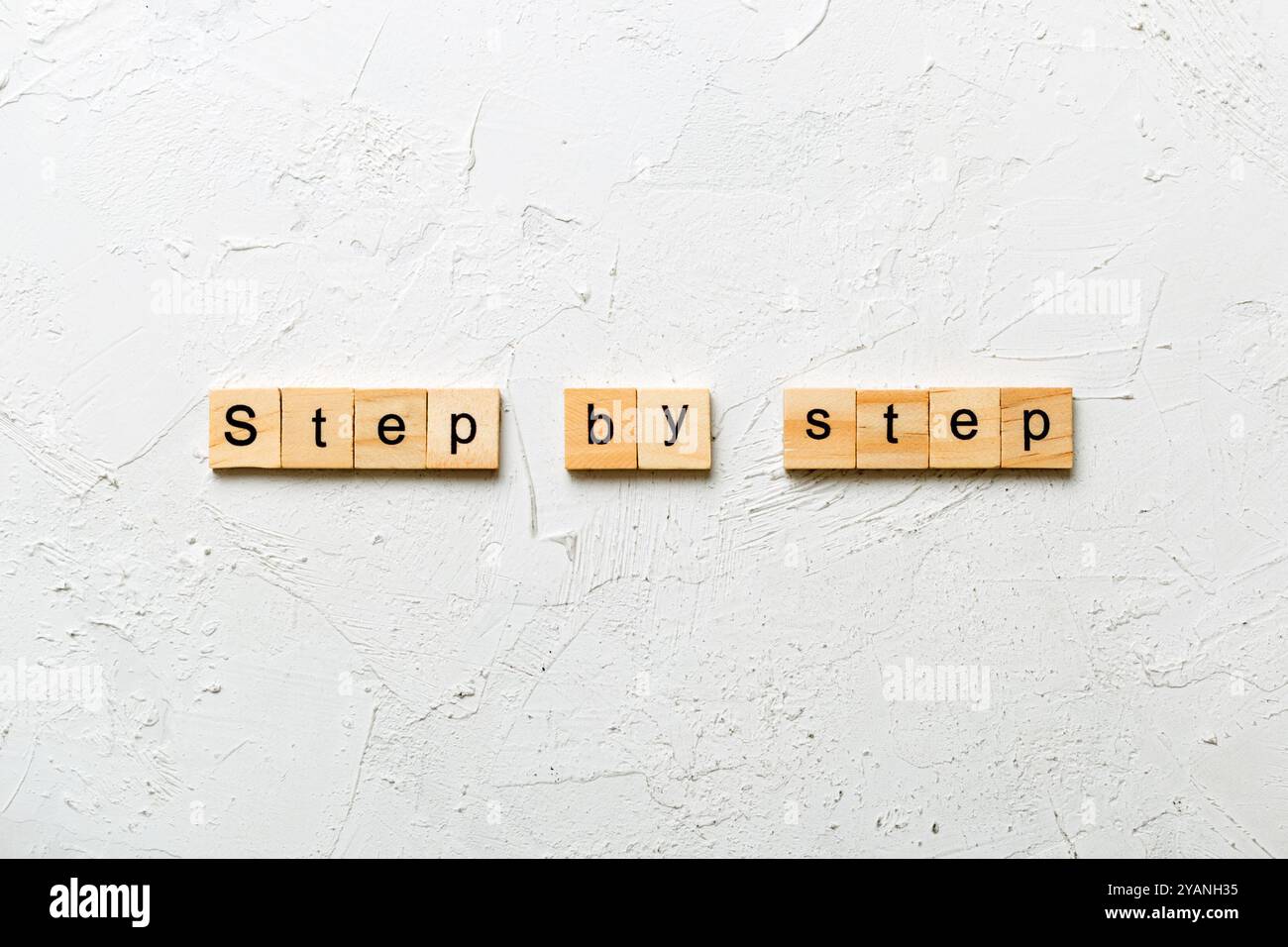 Schritt für Schritt Wort auf Holzblock geschrieben. Schritt für Schritt Text auf Tabelle, Konzept. Stockfoto