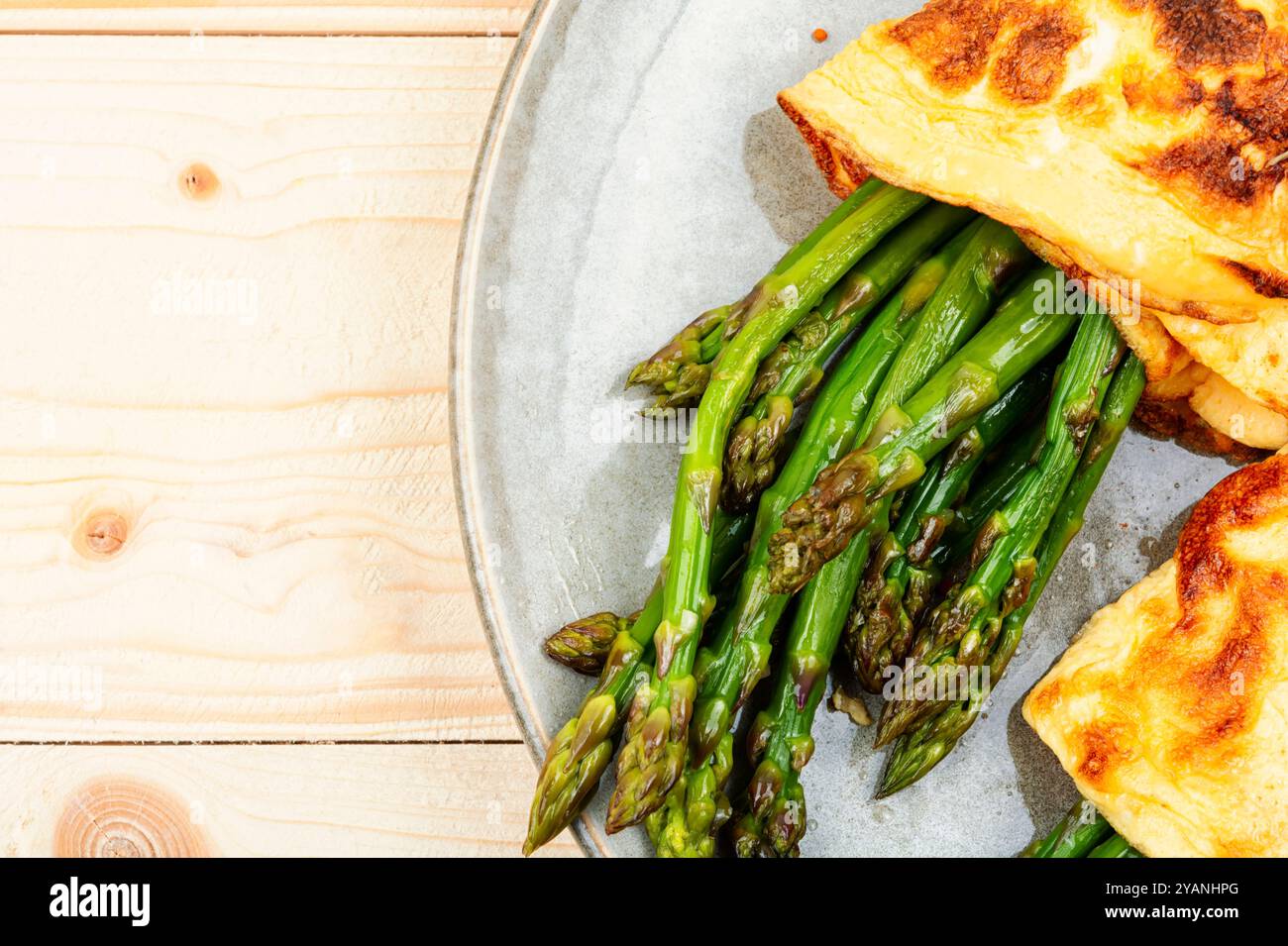 Ei-Omelett mit grünem Spargel auf rustikalem Holztisch gekocht. Kopierbereich Stockfoto