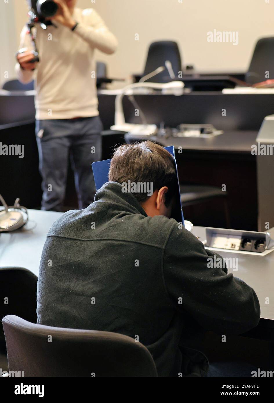 Hamburg, Deutschland. Oktober 2024. Ein 34-jähriger Mann (Front), der wegen Mordes und besonders schwerer Brandstiftung angeklagt ist, wartet im Gerichtssaal auf den Beginn des Prozesses. Der Angeklagte soll das Opfer mehrmals im Kopf- und Halsbereich mit einem Messer erstochen haben. Der Angriff führte zum Tod des Mannes. Danach soll der Angeklagte die Wohnung angezündet haben, um das Verbrechen zu vertuschen. Quelle: Ulrich Perrey/dpa/Alamy Live News Stockfoto