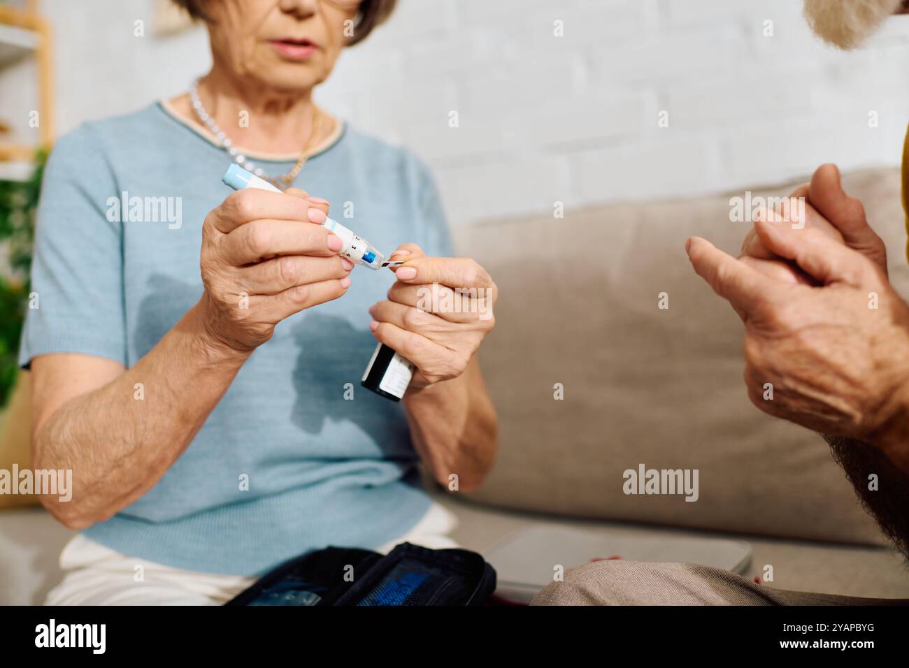 Ein älteres Paar teilt einen zärtlichen Moment, als sie ihm hilft, seinen Diabetes zu Hause zu behandeln. Stockfoto