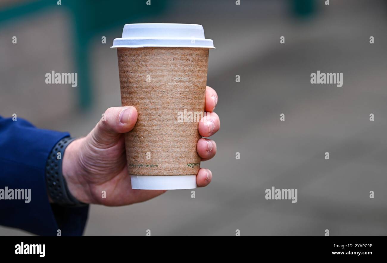 Männliche Hand hält eine Tasse Kaffee zum Mitnehmen. Stockfoto