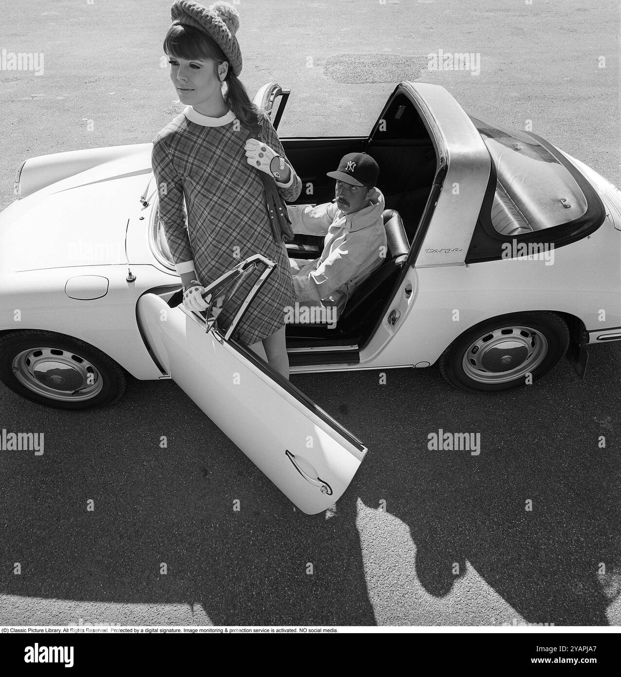 Porsche Juni 1967. Ein Modemodell, das in der Mode des Jahres gekleidet ist, bei einem Porsche 911 Targa Soft Window Modell. Ein Cabriolet mit einer Vinylscheibe in der Motorhaube, daher der Spitzname Soft Window. Auf dem Fahrersitz war professioneller Rennfahrer Sten Axelsson, der zu dieser Zeit Porsche fuhr. Foto mit Hasselblad Stockfoto