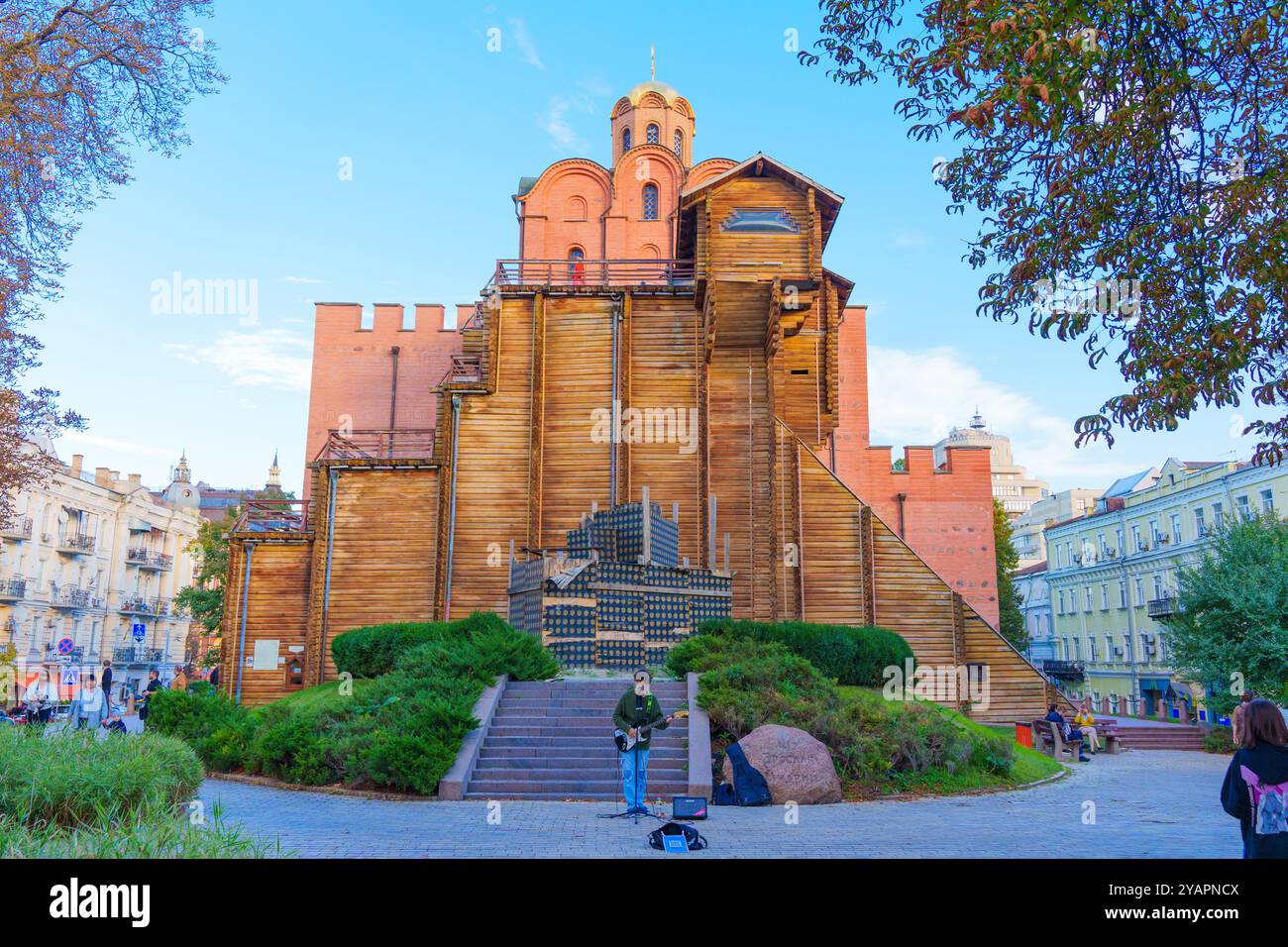 Kiew, Ukraine - 9. Oktober 2024: Szene eines Gitarrenspielers vor der Festung Golden Gate, umgeben von Grün und Besuchern in Kiew. Stockfoto