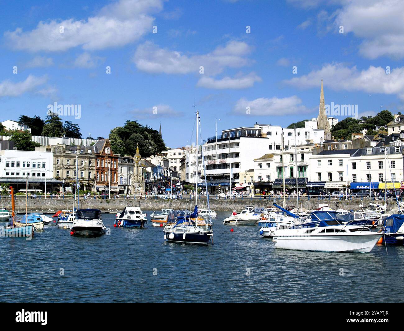 Eine Ansammlung kleiner Boote, die im Innenhafen von Torquay vertäut sind, dahinter befindet sich ein denkmalgeschützter Uhrenturm, der 1902 als Denkmal für Torquay erbaut wurde Stockfoto