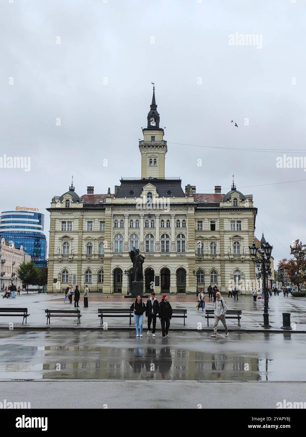 Menschen, die während des Regentages laufen, Bänke am Rathaus auf dem Freiheitsplatz, Novi Sad, Serbien, Oktober 2024 Stockfoto