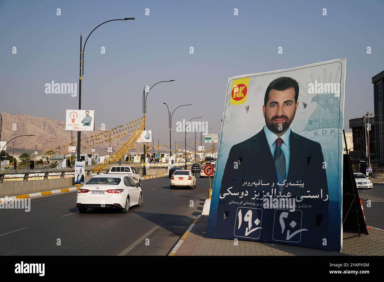 Ein Auto fährt an einem Wahlbanner des Kandidaten der Kurdischen Demokratischen Partei (KDP/PDK) vor den Wahlen zum Kurdischen Regionalparlament in Duhok, Irak, vorbei. Stockfoto