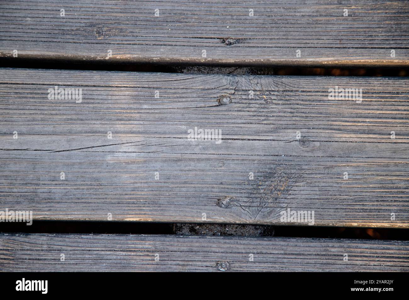 Nahaufnahme einer verwitterten Holzterrasse, die die natürliche Körnung und Textur des alten Holzes zeigt, perfekt für Hintergründe und Texturen Stockfoto