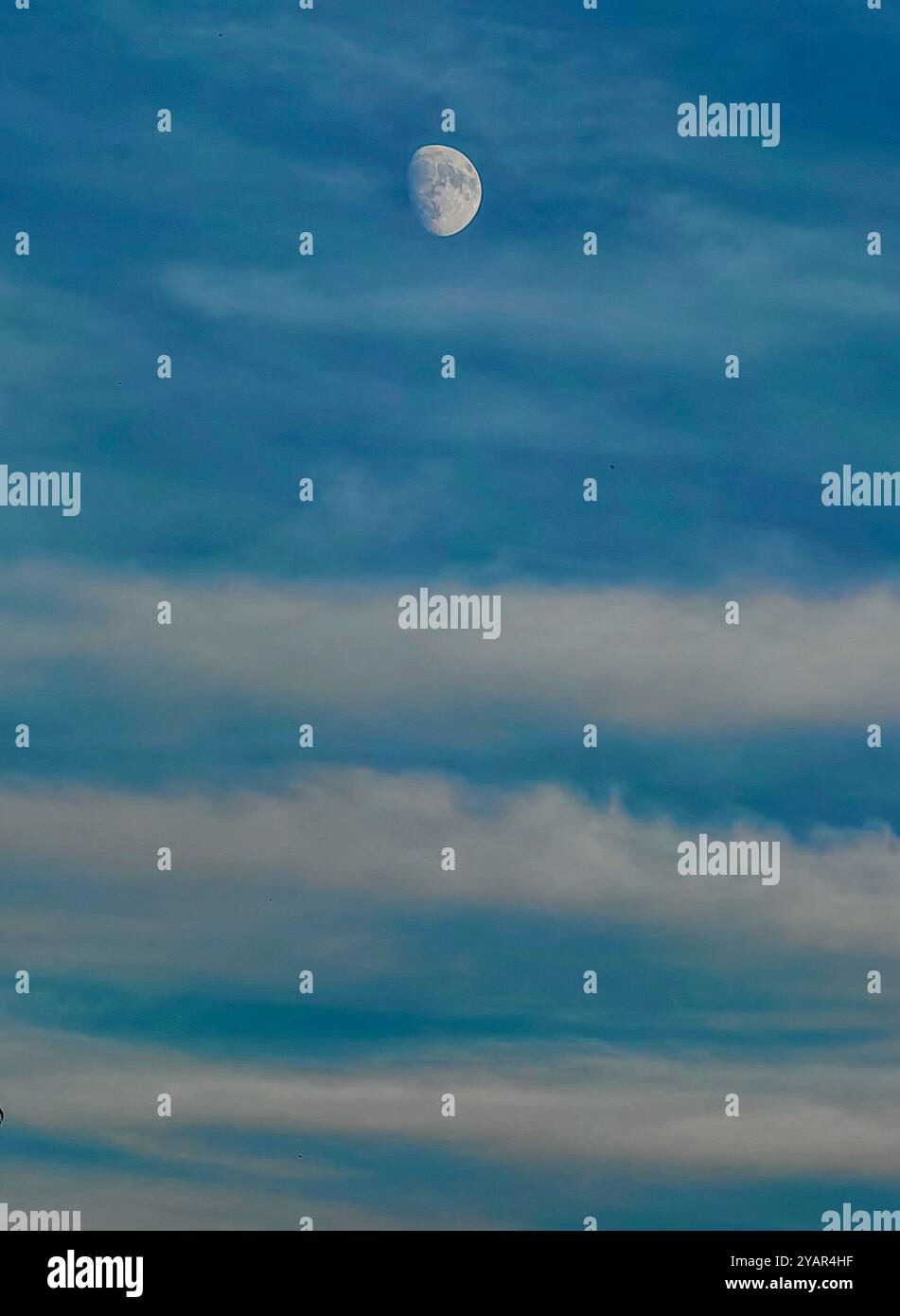 Hoch im Himmel: Mondphase als Erdsatellit mit Wolken als führende Linien, Top-of-the-World-Konzept Stockfoto