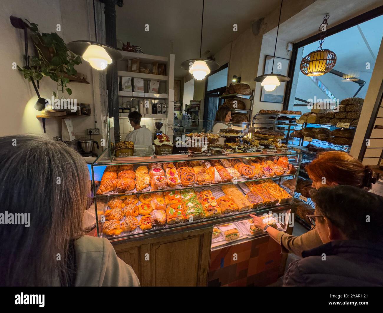 Die Kunden sprechen in der Alma Nomad Bakery, Madrid, Spanien - Smartphone-aufgenommenes Stockfoto