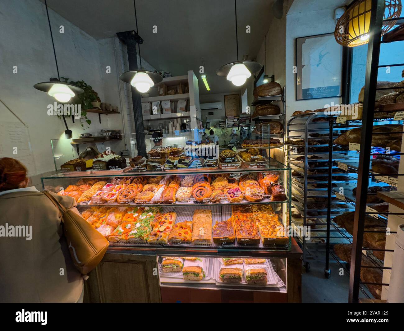 Die Kunden sprechen in der Alma Nomad Bakery, Madrid, Spanien - Smartphone-aufgenommenes Stockfoto