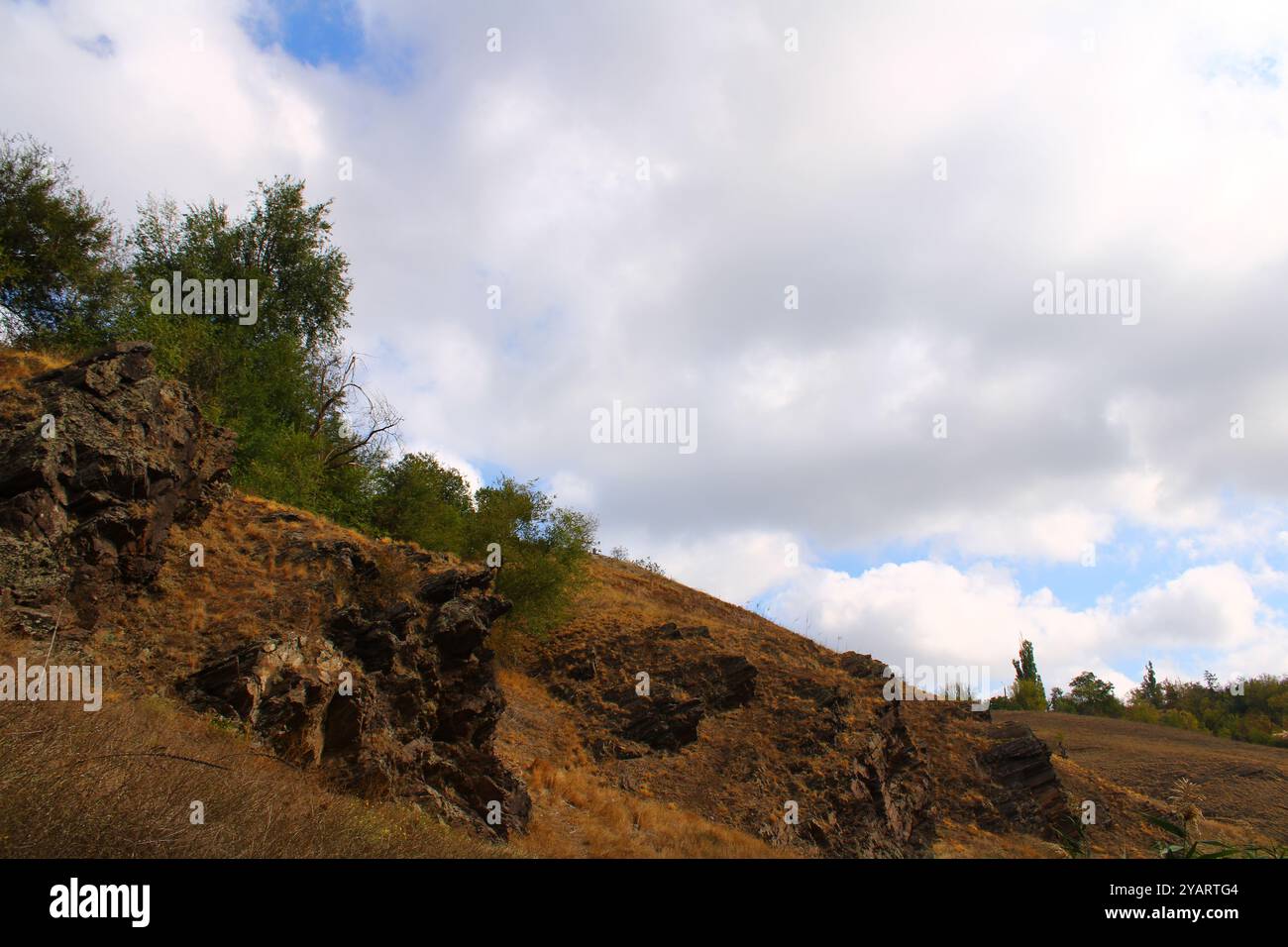Gesteinsaufschlüsse am Hang erscheinen als natürliche Vorsprünge, die durch Erosion und geologische Prozesse gebildet werden. Stockfoto