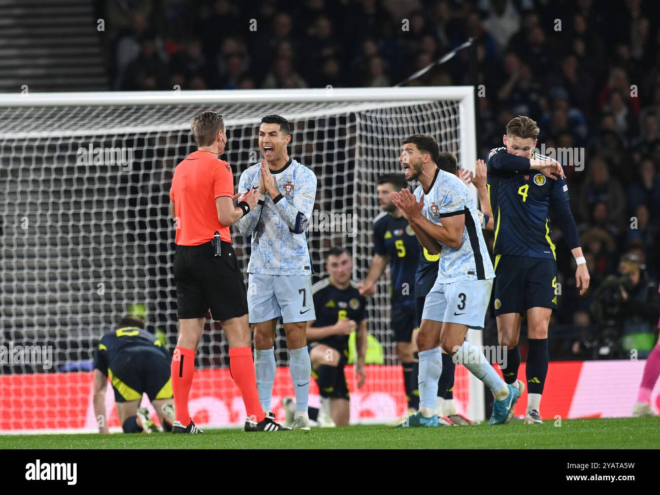 . Schottland gegen Portugal UEFA Nations League: League A, Gruppe 1 15. Oktober 2024 Hampden Park, Glasgow. Schottland . Cristiano Ronaldo & Ruben Dias (Portugal) plädieren mit Schiedsrichter Lawrence Visser (BEL) Credit: eric mccowat/Alamy Live News Stockfoto