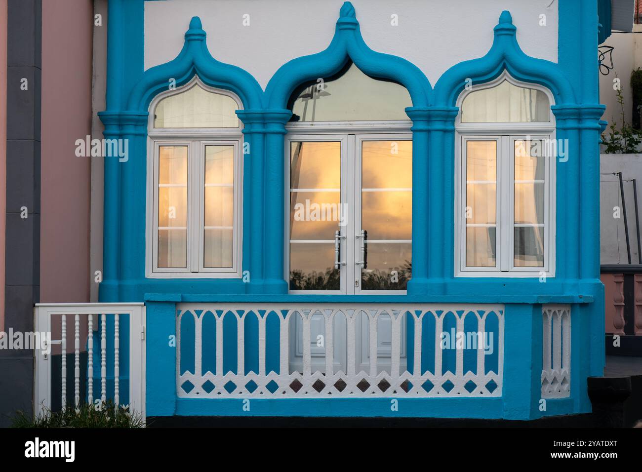 Reflexionen des Sonnenuntergangs am Fenster eines traditionellen hellblauen religiösen Imperios in Praia da Vitoria, Azoren Stockfoto